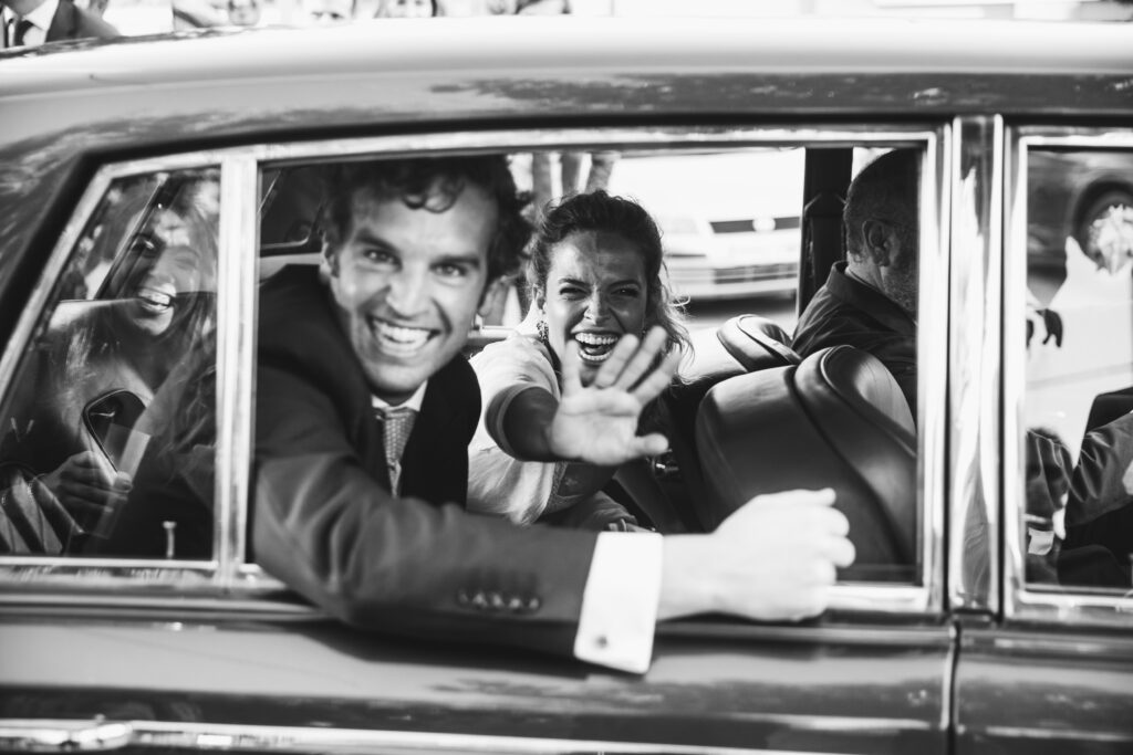 Los novios saludando desde el coche