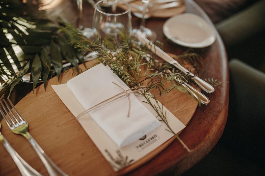 Detalle de la mesa con servilleta de lino y ramas de olivo