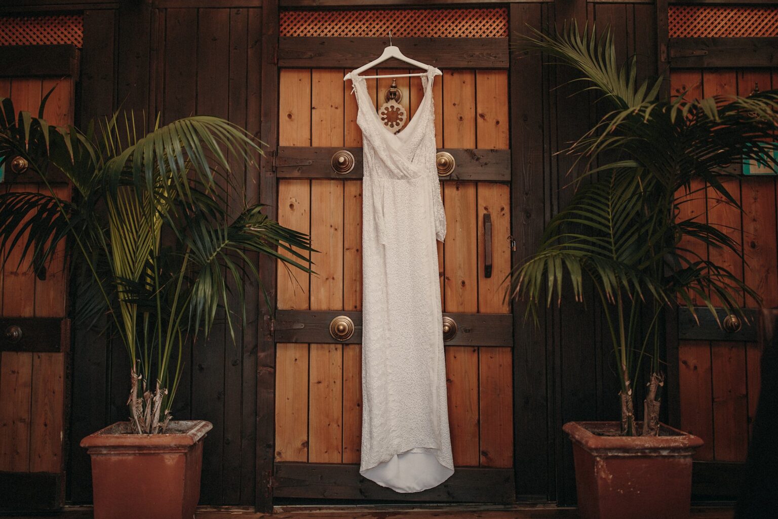 Vestido de novia de Natalia colgado entre palmeras